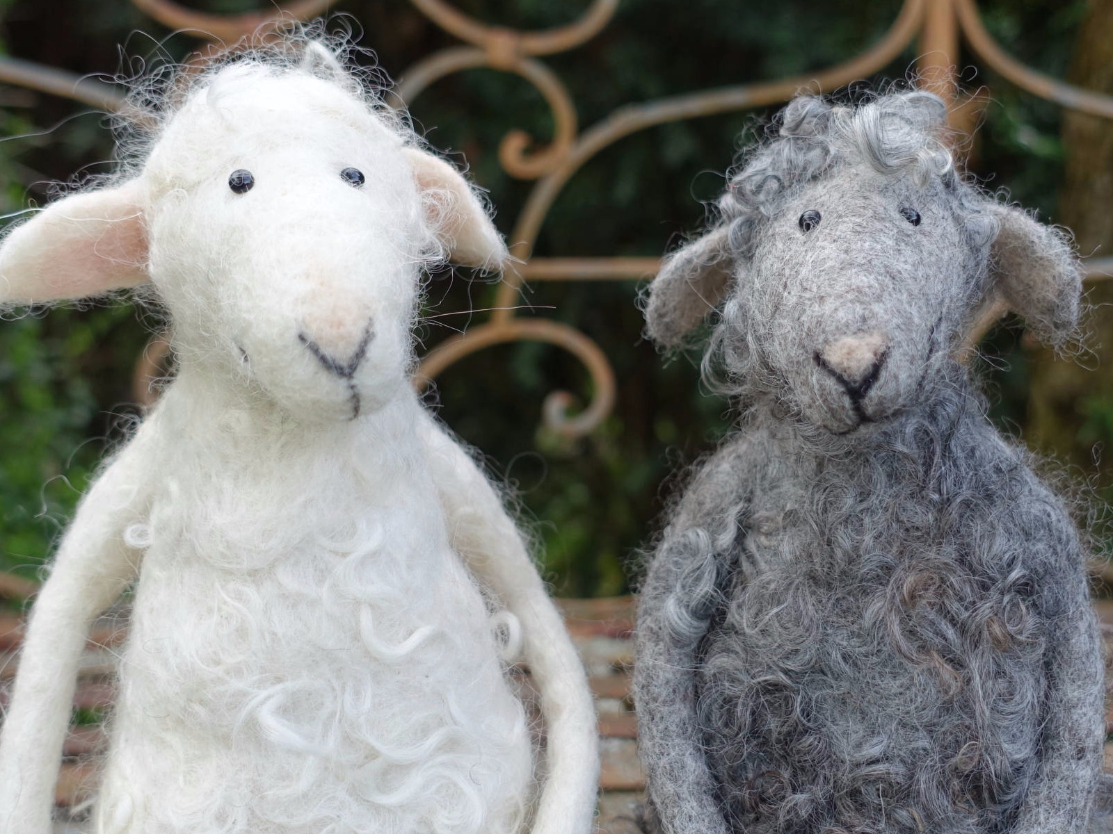 Zwei gefilzte Schafe, weiß und grau.