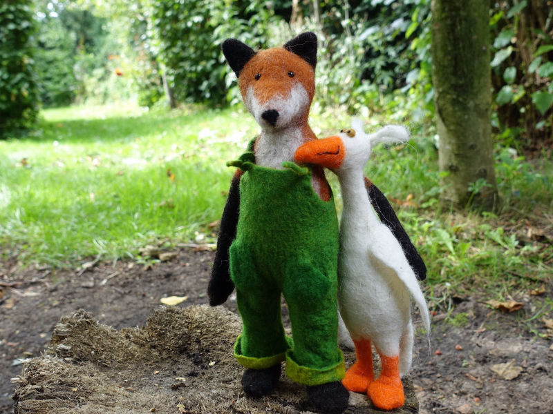 Filzfuchs mit grüner Latzhose und weißer Gans