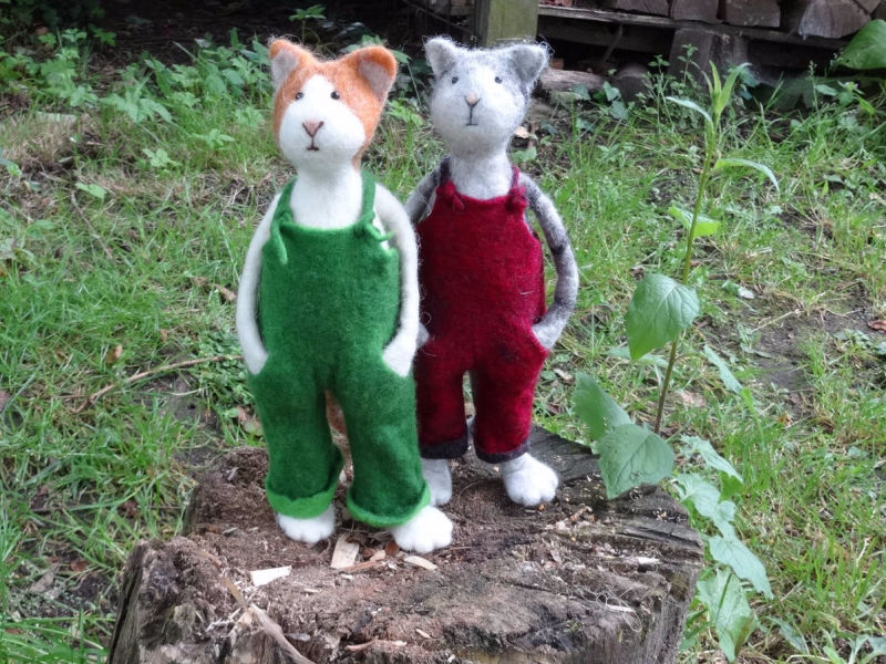 Zwei gefilzte Katzen mit grüner und roter Latzhose