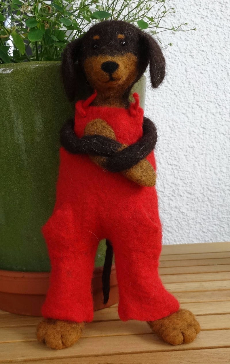 Ein gefilzter Dackel mit roter Latzhose